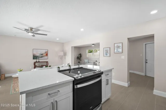 a kitchen that has a sink and a stove with white walls