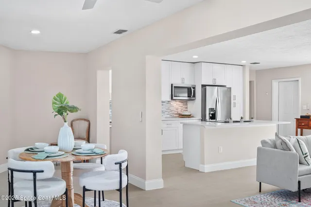 a living room with furniture a refrigerator and a dining table