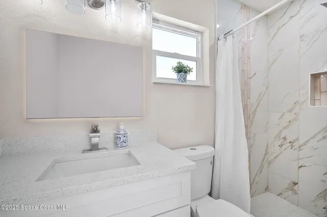 a bathroom with a sink a toilet and a window