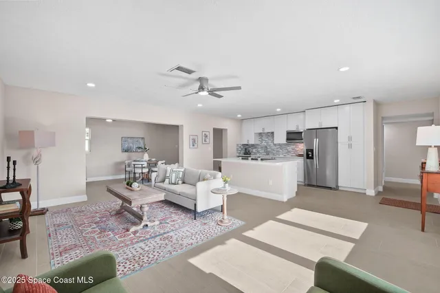 a living room with furniture and kitchen view