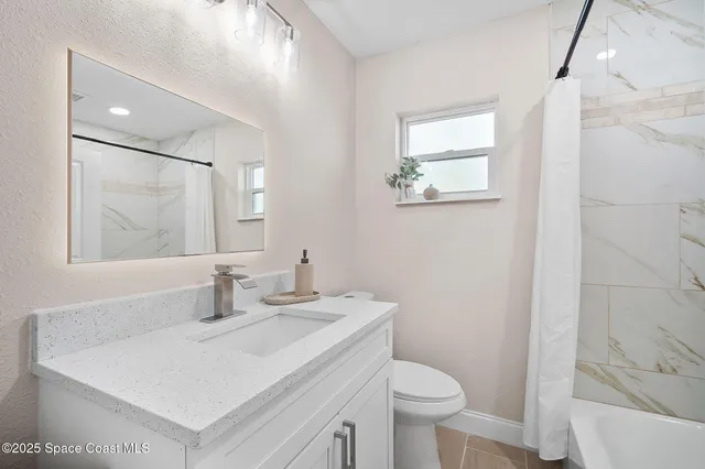 a bathroom with a sink toilet and a mirror