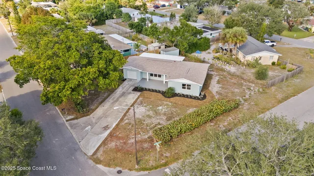 an aerial view of a house with a yard and lake