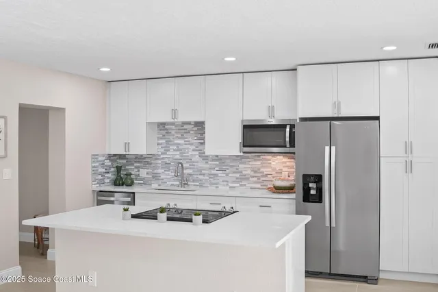 a kitchen with stainless steel appliances a refrigerator sink and microwave