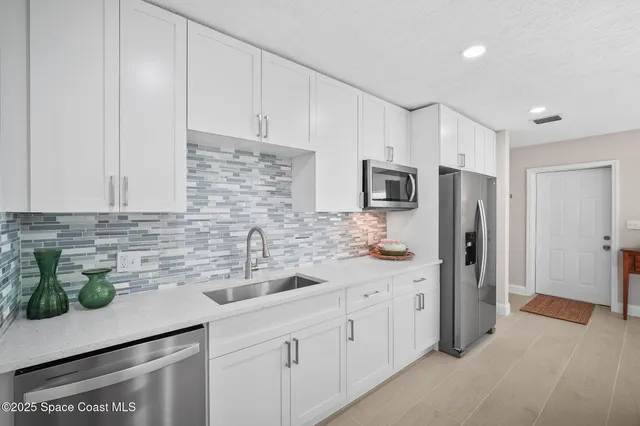a kitchen with stainless steel appliances white cabinets and a sink