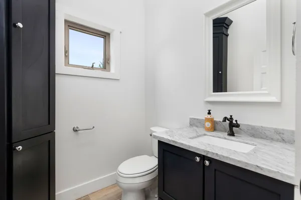 a bathroom with a granite countertop sink toilet and mirror