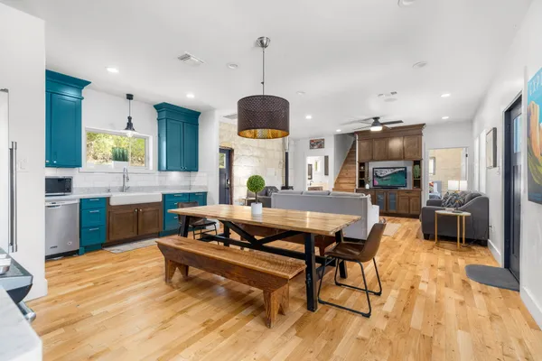 a living room with stainless steel appliances kitchen island granite countertop furniture wooden floor and a view of kitchen