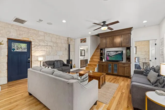 a living room with couches a fireplace and a kitchen view