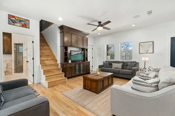 a living room with couches a fireplace and a kitchen view