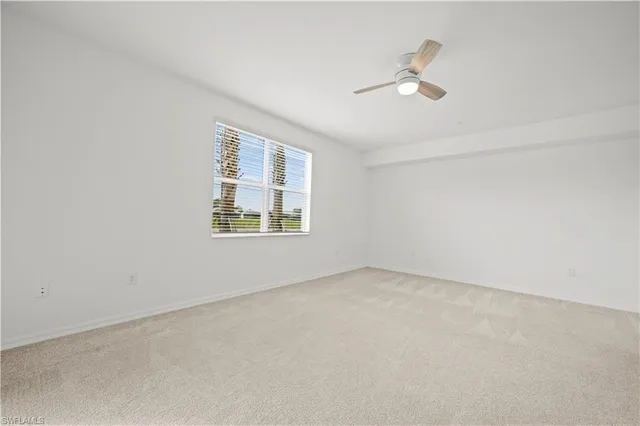 an empty room with windows and ceiling fan