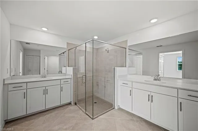 a spacious bathroom with a shower sink and mirror