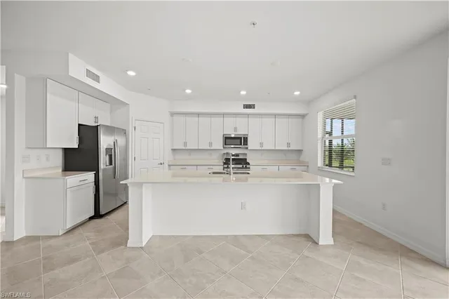 a view of kitchen with refrigerator sink and stove