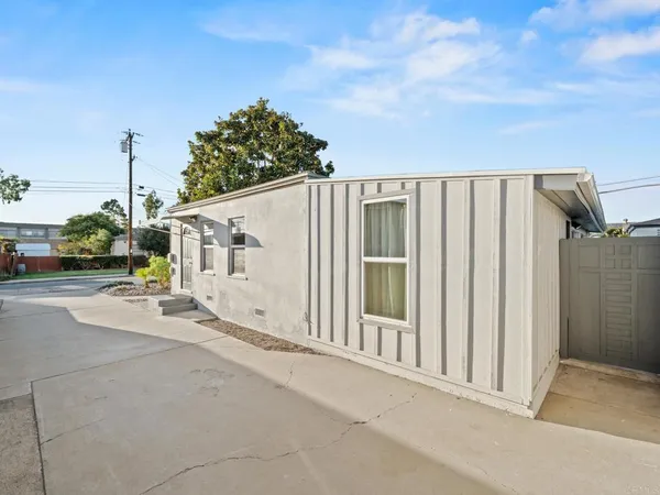 a view of a house with backyard and parking