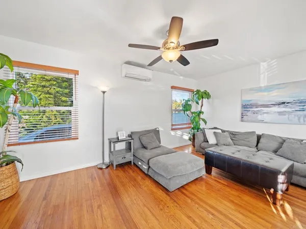 a living room with furniture and a wooden floor