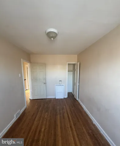 a view of a room with wooden floor and a window