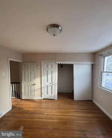 an empty room with windows and closet