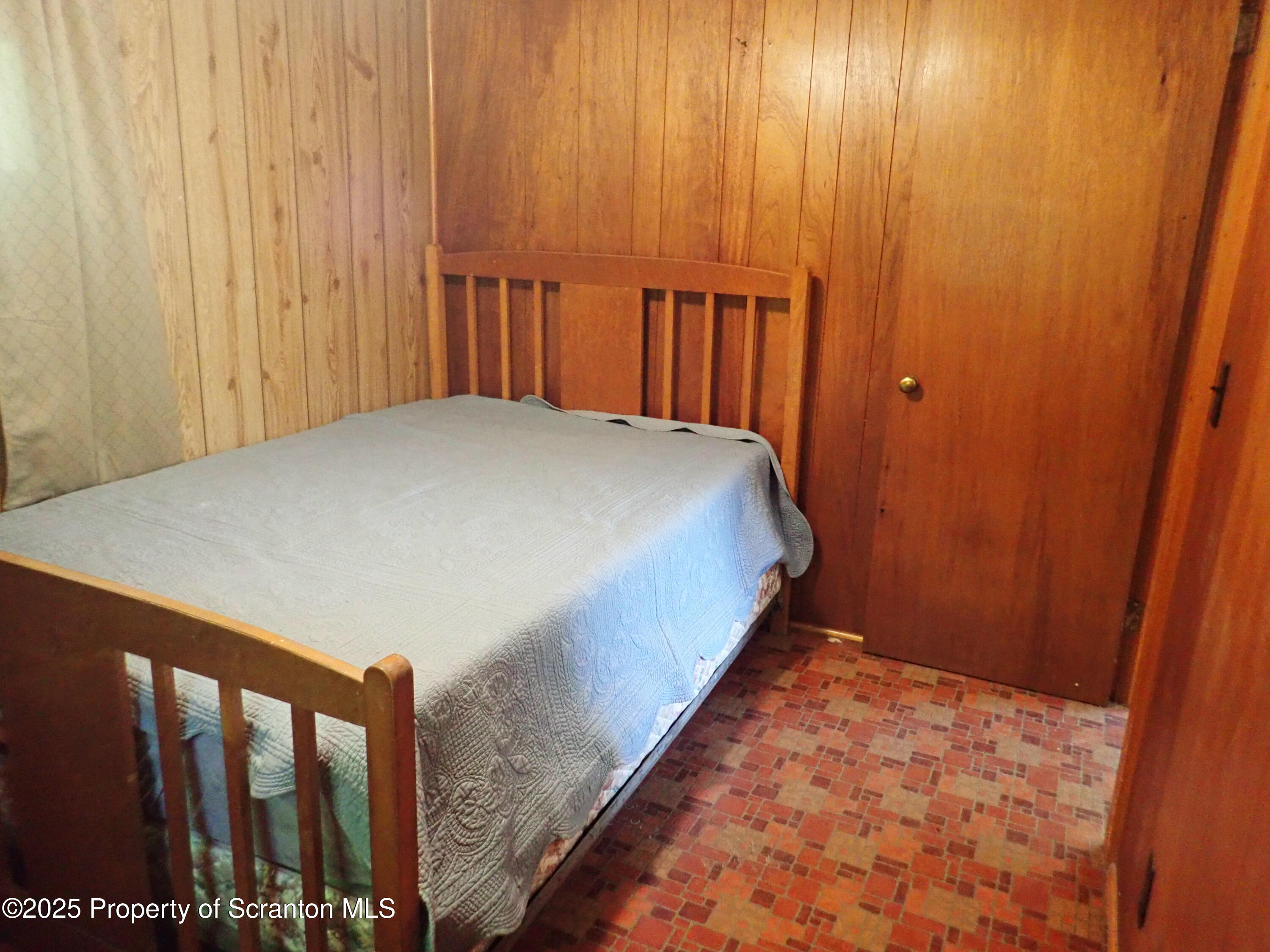 430 Crescent Lake Road Meshoppen, PA 18630 - Photo 32 of 51 a bed sitting in a bedroom next to a wooden door