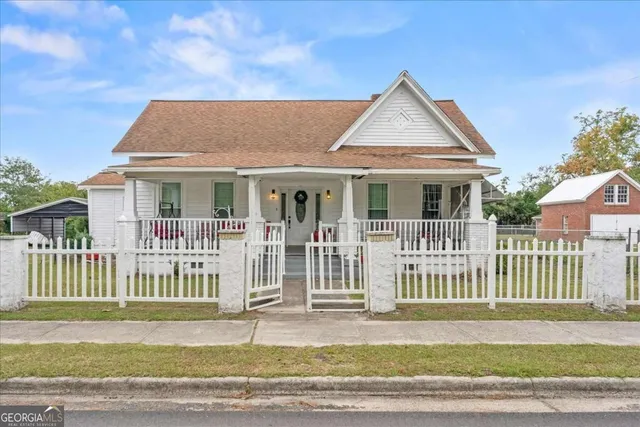a view of a house with a small yard and wooden fence
