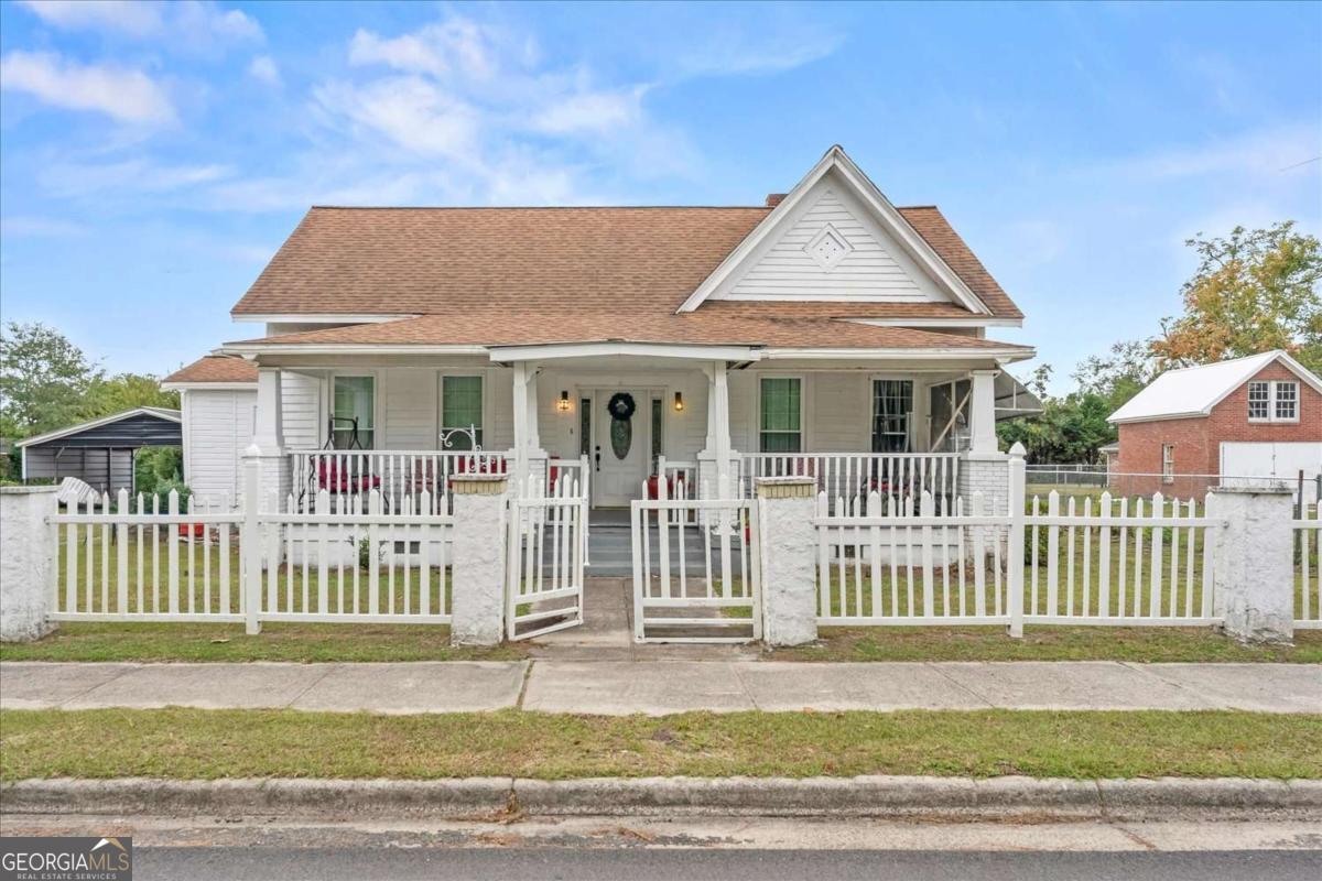 24 East Calhoun Street Wadley, GA 30477 - Photo 1 of 1 a view of a house with a small yard and wooden fence