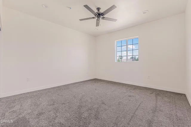 an empty room with chandelier fan