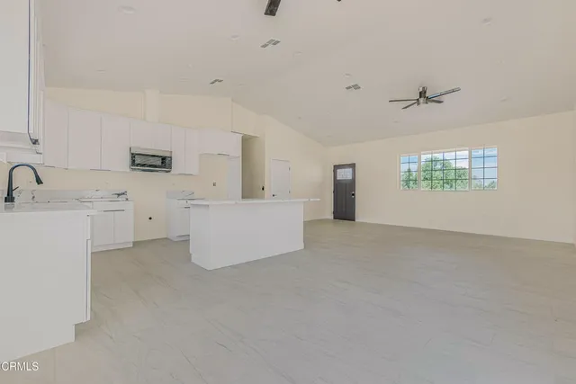 a kitchen with white cabinets sink and window