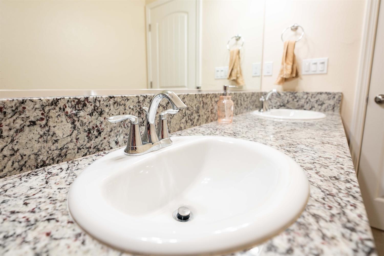 1818 Softwind Drive Tulare, CA 93274 - Photo 27 of 46 a bathroom with a granite countertop sink and a mirror