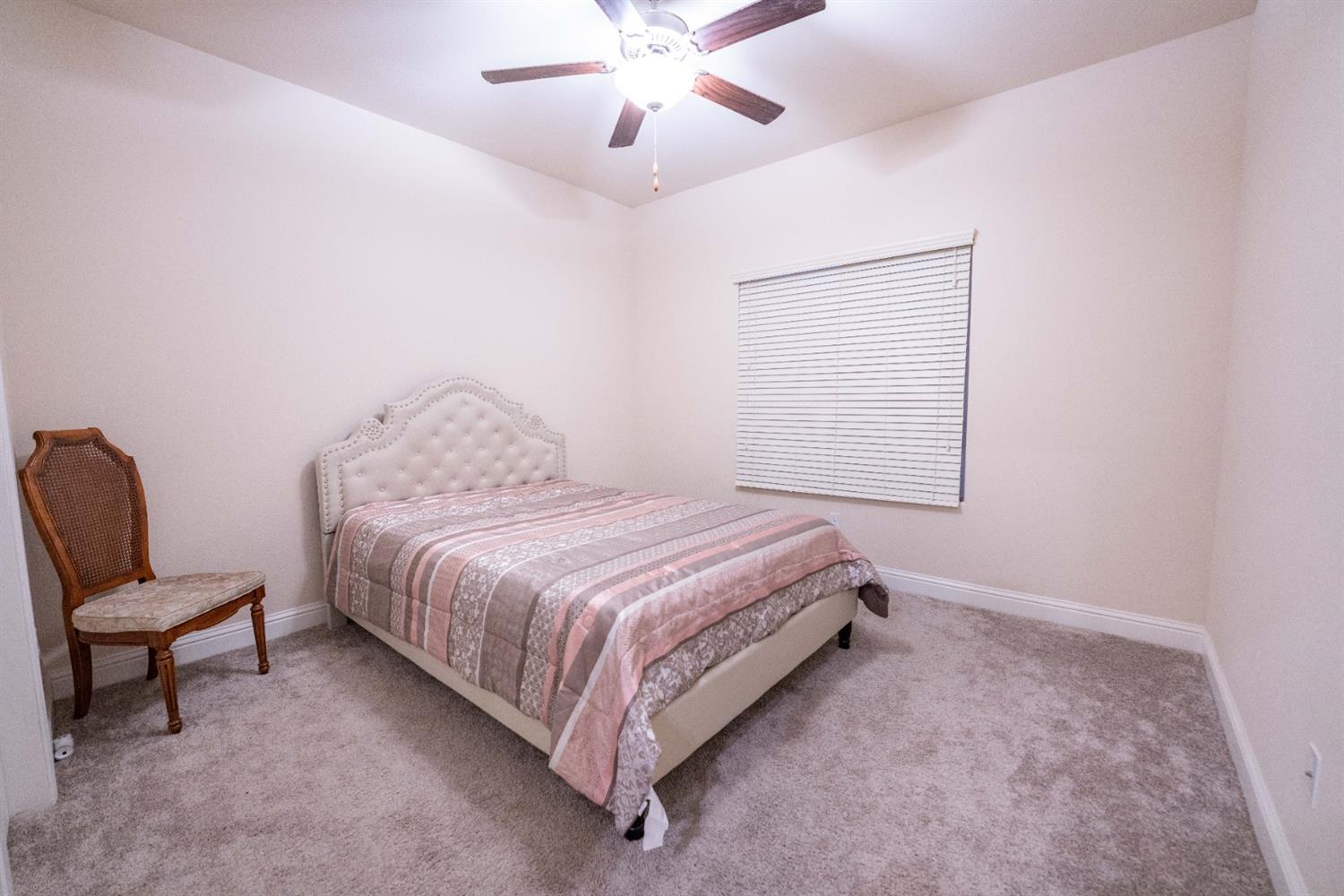 1818 Softwind Drive Tulare, CA 93274 - Photo 35 of 46 a bedroom with a bed and a chair