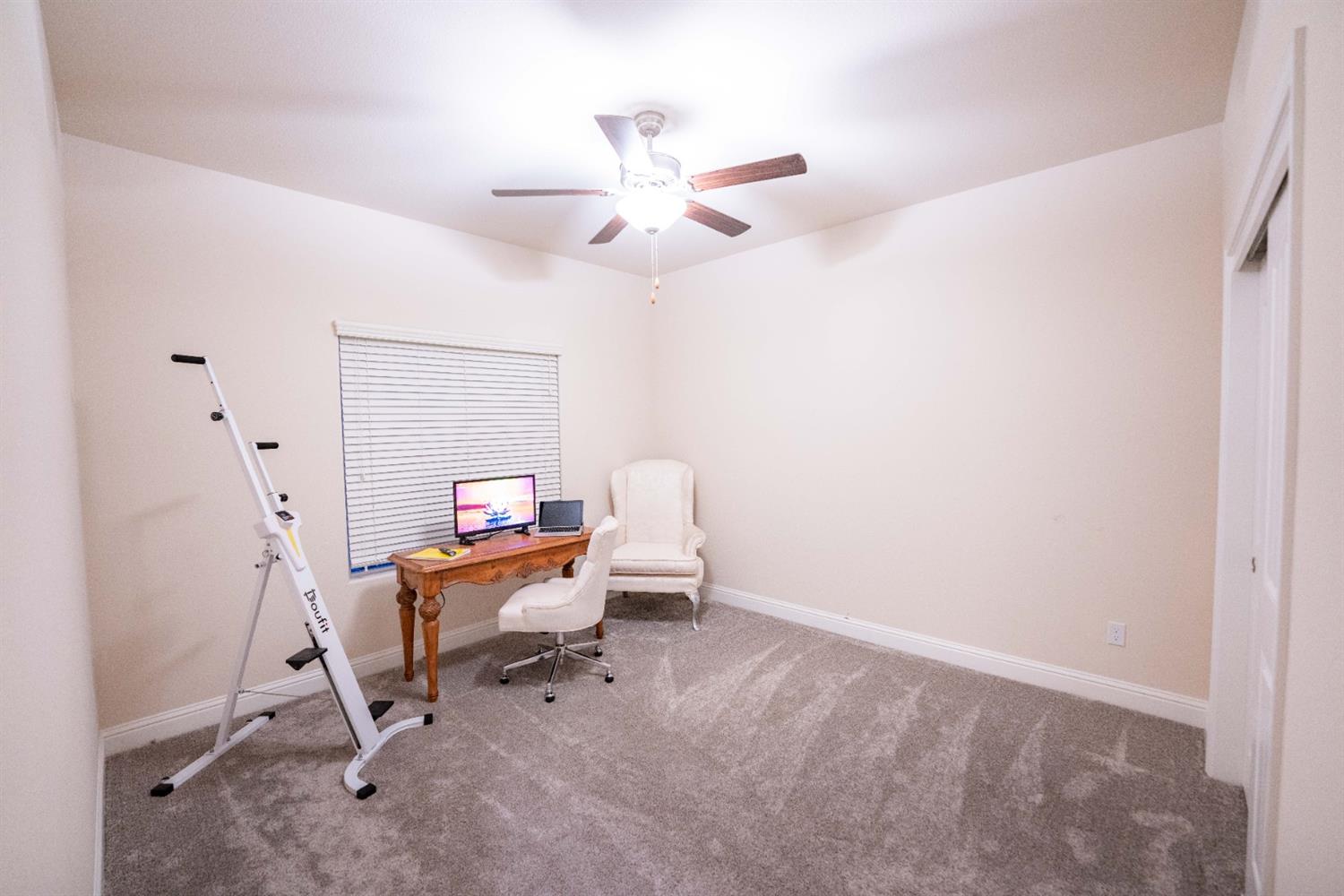 1818 Softwind Drive Tulare, CA 93274 - Photo 36 of 46 a work room with furniture and a chandelier fan