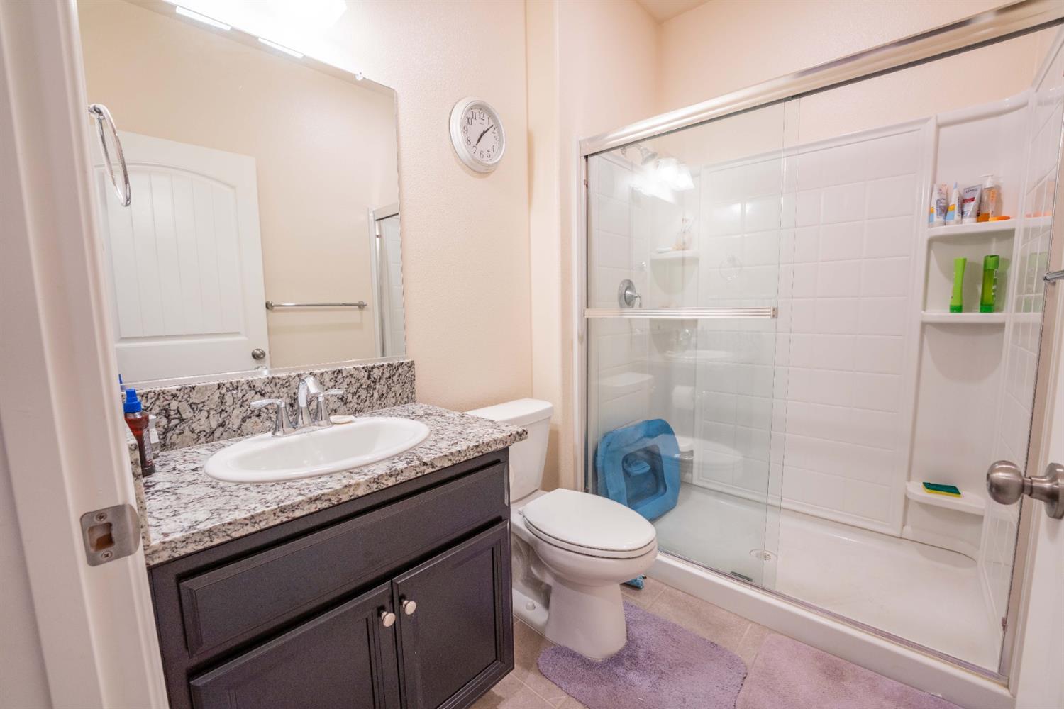 1818 Softwind Drive Tulare, CA 93274 - Photo 39 of 46 a bathroom with a granite countertop sink toilet and shower