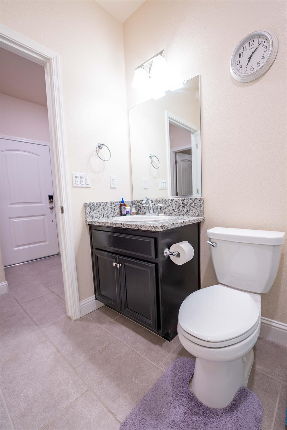 1818 Softwind Drive Tulare, CA 93274 - Photo 40 of 46 a bathroom with a toilet a sink and a mirror