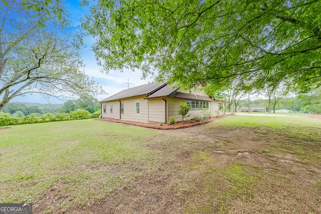 a house with green field in front of it