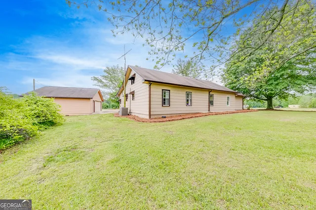 a front view of house with yard and trees in the background