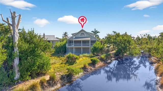 a front view of a house with a yard and potted plants