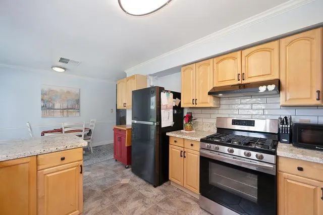 a kitchen with stainless steel appliances granite countertop a stove refrigerator sink and microwave