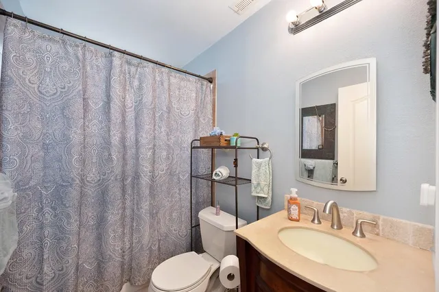 a bathroom with a toilet sink and mirror