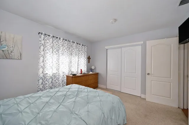 a bedroom with a bed and a flat tv screen in it