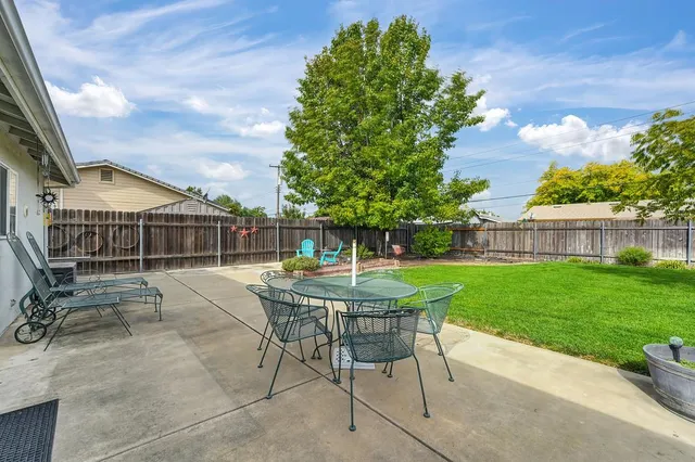 a view of a house with backyard and sitting area