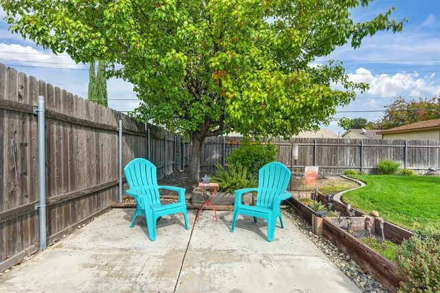 a view of a chairs in patio with wooden fence