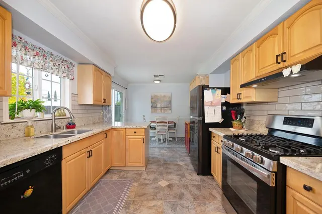 a kitchen with stainless steel appliances granite countertop a stove a sink dishwasher and a refrigerator