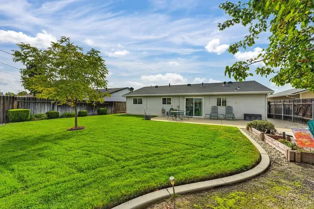 a view of a house with a backyard and a patio
