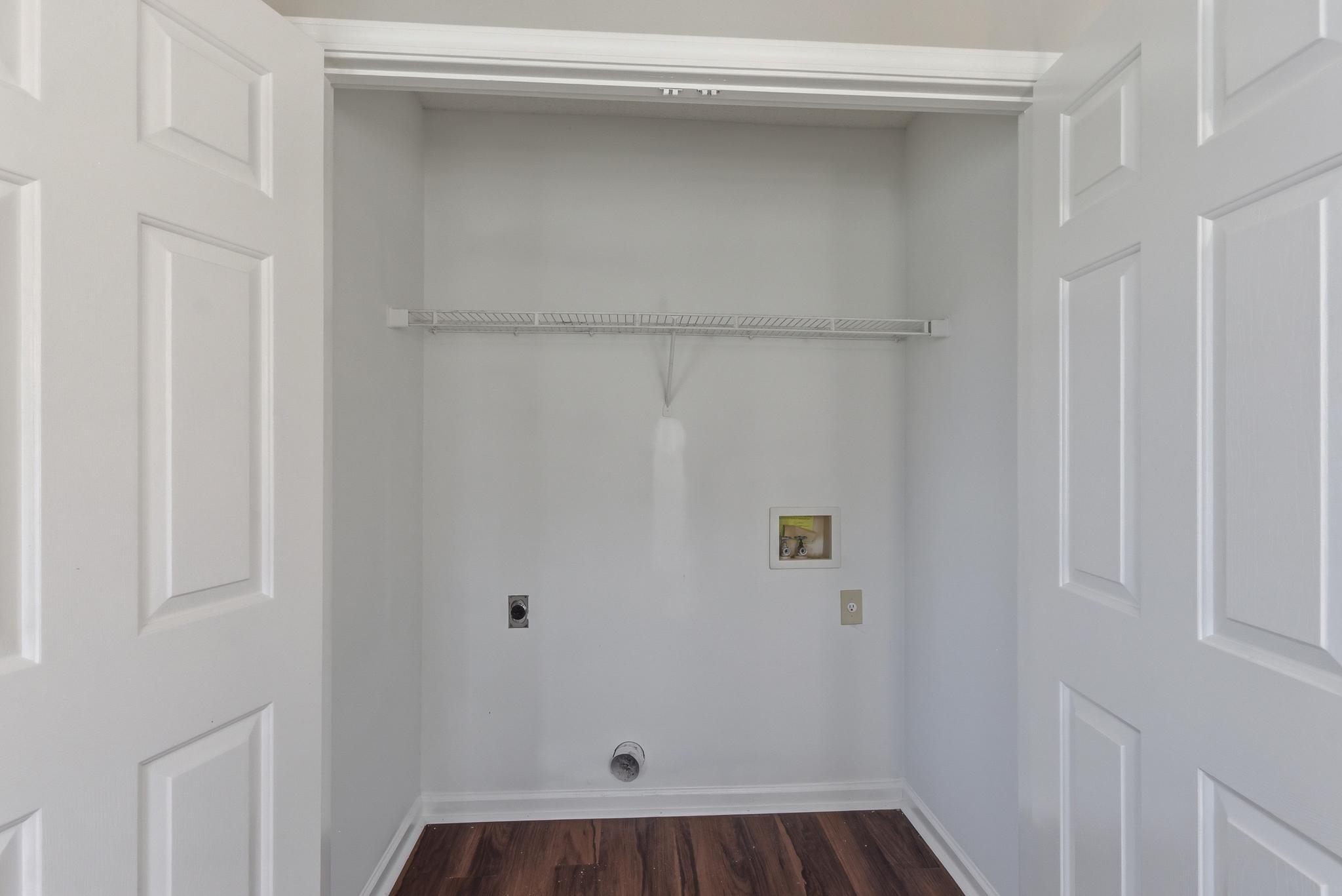 4101 Long Creek Road Memphis, TN 38125 - Photo 30 of 36 Dedicated laundry area featuring wood-finish flooring, light gray walls, and a wire storage shelf
