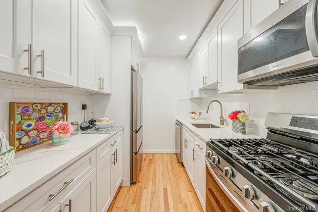 a kitchen with stainless steel appliances a stove a sink and cabinets