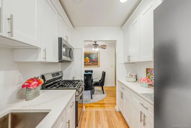 a kitchen with stainless steel appliances granite countertop a sink stove and white cabinets