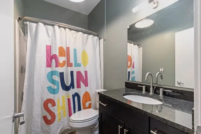 a bathroom with a sink a toilet and shower curtain