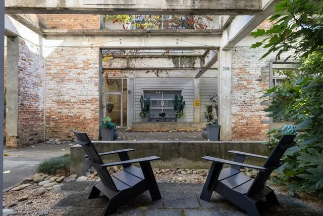 a living room with couches and a fireplace with wooden floor