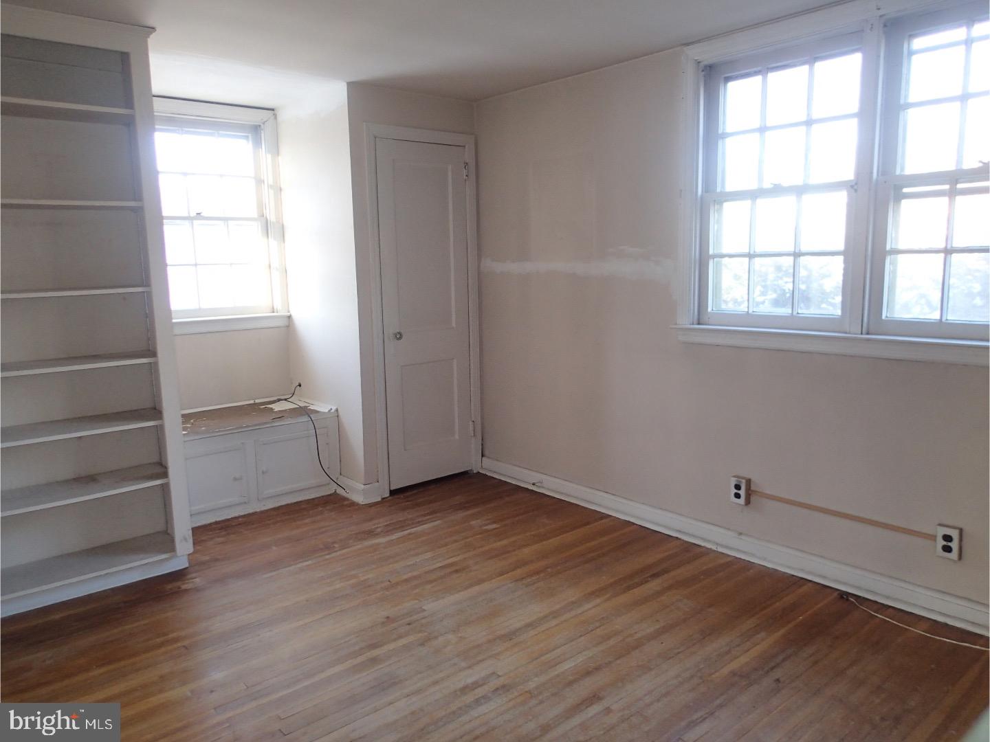 249 Fairview Road Springfield, PA 19064 - Photo 12 of 16 an empty room with wooden floor closet and windows