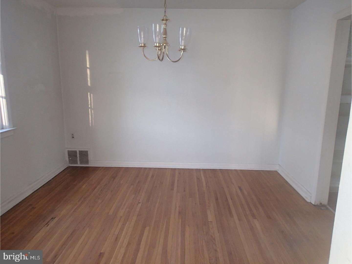 249 Fairview Road Springfield, PA 19064 - Photo 5 of 16 a view of an empty room with wooden floor and chandelier