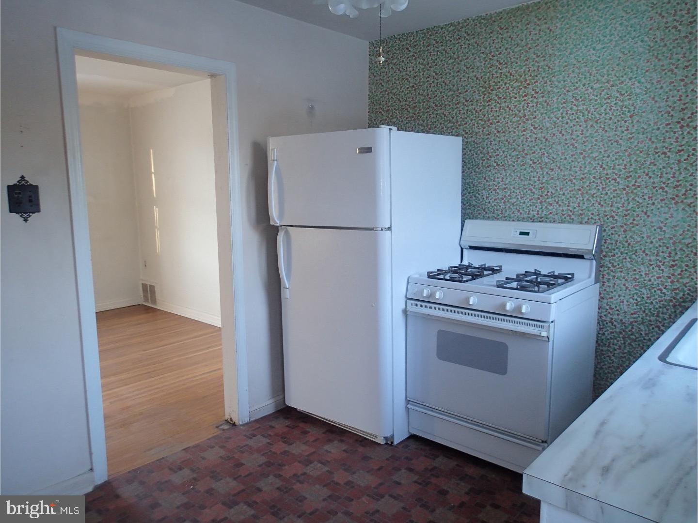 249 Fairview Road Springfield, PA 19064 - Photo 7 of 16 a view of a kitchen with a stove refrigerator and wooden floor