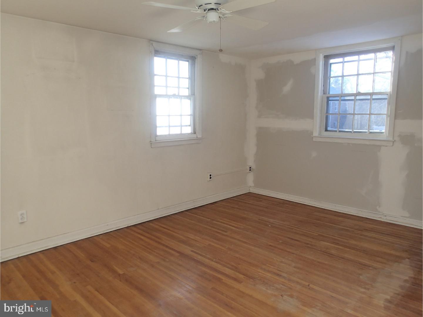 249 Fairview Road Springfield, PA 19064 - Photo 9 of 16 an empty room with wooden floor and windows