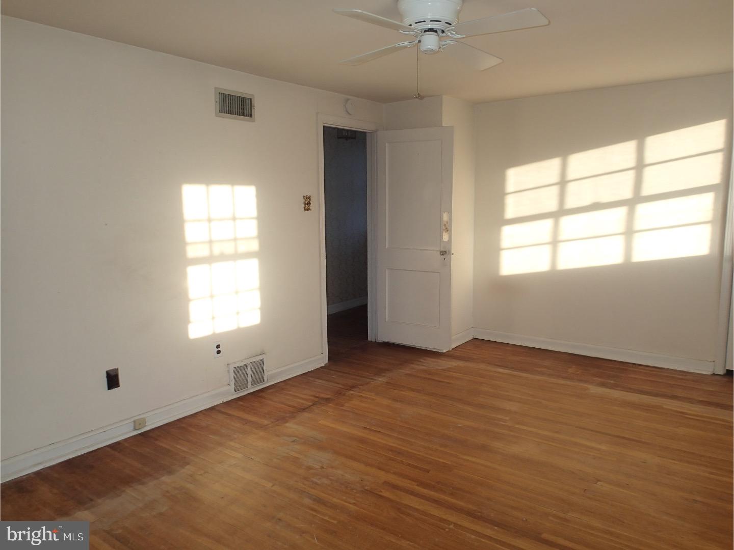 249 Fairview Road Springfield, PA 19064 - Photo 10 of 16 an empty room with wooden floor windows and fan