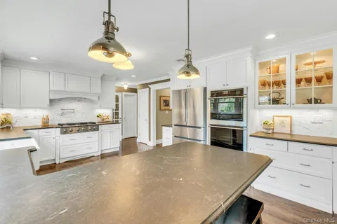 a large kitchen with kitchen island a stove a sink a center island and windows